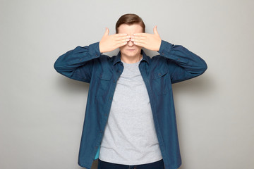 Portrait of serious mature man covering eyes with both hands