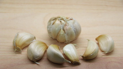 Unfocused, Blurry selective focus image, Garlic cloves on rustic in wooden table. Fresh peeled garlics and bulbs.