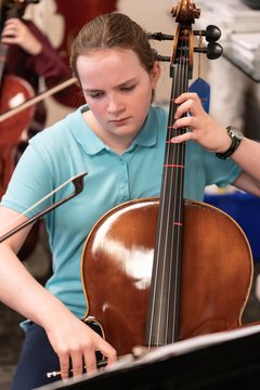 Teenage girl playing cello in classroom