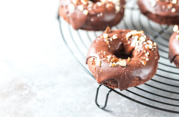 Chocolate donuts on a light concrete background. National Donut Day. Homemade baking.