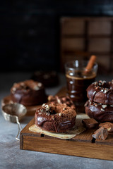 Chocolate donuts with chocolate glaze, nuts and coffee. National Donut Day. Homemade baking.