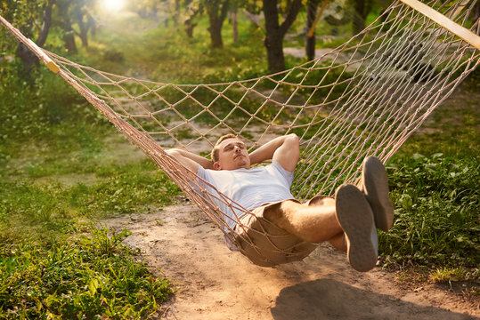 Man Relax In Hammock Garden. Summer Vibes In Green Forest