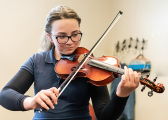 Teenage girl playing violin in classroom