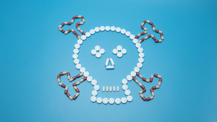 Many pills symbol a skull shape on blue background, Blank for design. Top view..