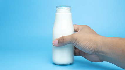 Fresh milk bottle handle on blue background, Closeup Front view Food concept..