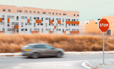 Panning with city in the background, with dry field and clear sky and STOP signal