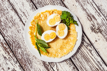 Boiled chicken eggs with two yolks in a cut on a pancake.
