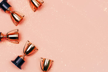 Winner cups on a pink background. Banner with a place for text. Flat lay style.