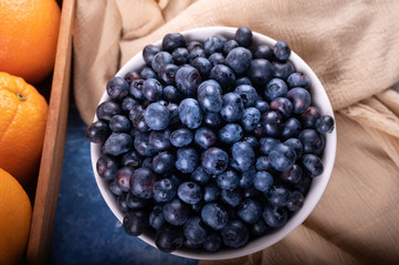 Blueberry and Fresh oranges fruit on wood basket.