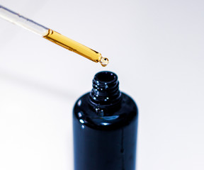 Serum cosmetics bottle on white background, close-up