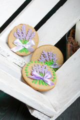 Gingerbread cookies decorated with glaze. On some ribbons tied to a bow. Lie on white painted boards.