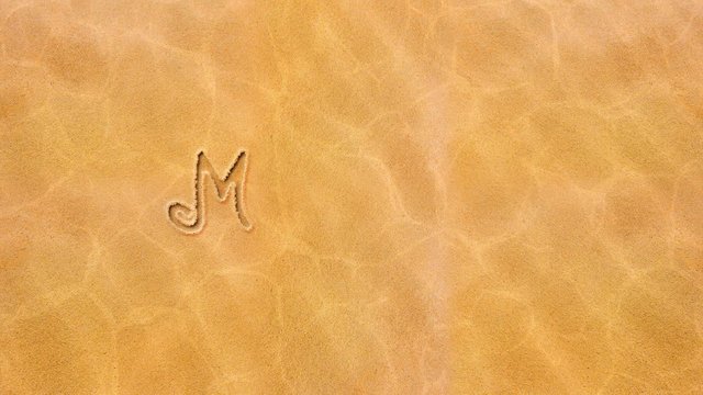 Handwritten animated text in the sand, day of the week-Monday.
