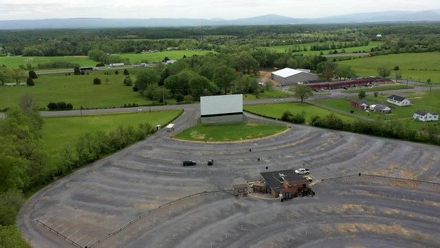 Backing away from a large screen in a drive-in movie theater in America.