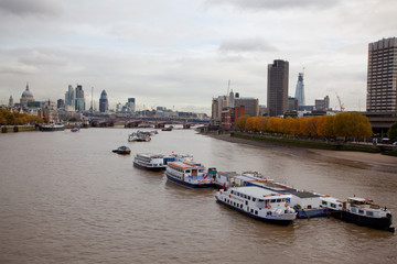 the River Thames looking east towards St.Pauls cathedral and the city with boats in the foreground 