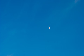 The growing moon or crescent moon is on a canvas of blue clear sky. Earth satellite, space. Evening