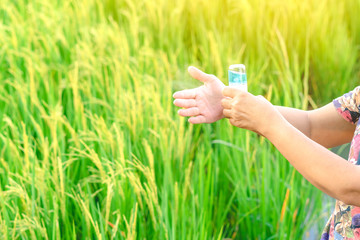 Woman using alcohol nano mist sprayer antiseptic cleaning on her hands protection during...