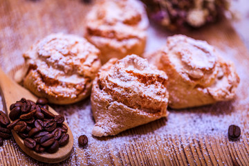 Natural baked coconut cookies or cocoanut macaroons on wooden plate top view, copy space. Homemade cake with coffee beans.