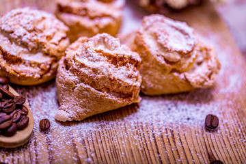 Natural baked coconut cookies or cocoanut macaroons on wooden plate top view, copy space. Homemade cake with coffee beans.