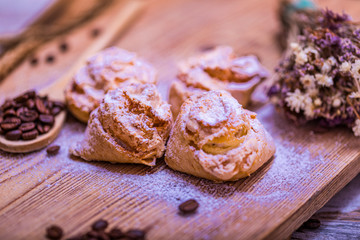 Natural baked coconut cookies or cocoanut macaroons on wooden plate. Homemade diet biscuits on rustic background.