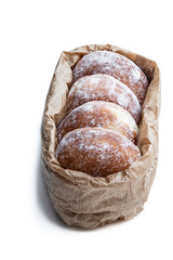 Freshly baked doughnuts stuffed with strawberry jam in paper bag isolated on white