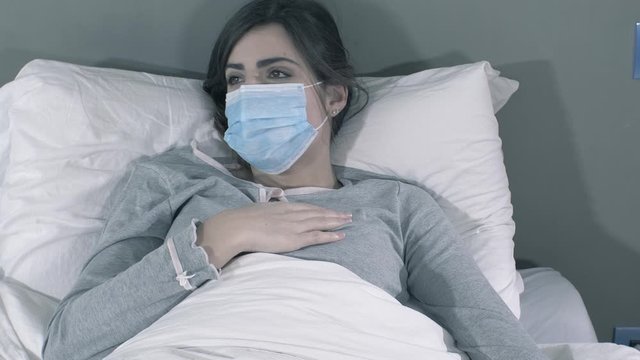 Closeup of sick woman with coronavirus in hospital bed