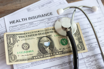 One us dollar with face mask on insurance paper bill. Health care cost during coronavirus covid outbreak concept 