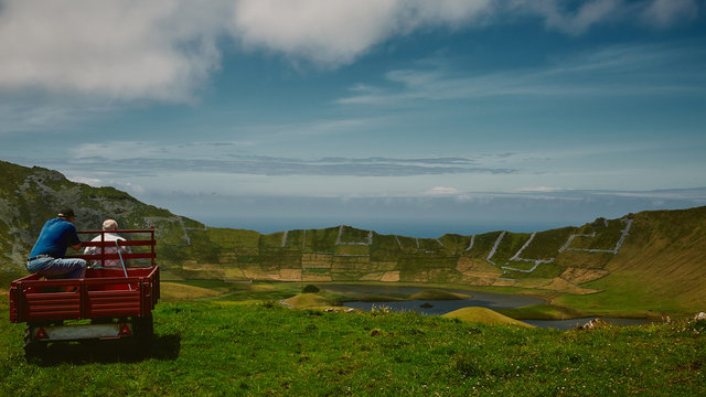 old men look out into volcano and lake