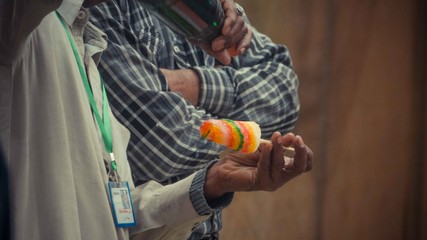 Man's hand holding a colorful popsicle sticks