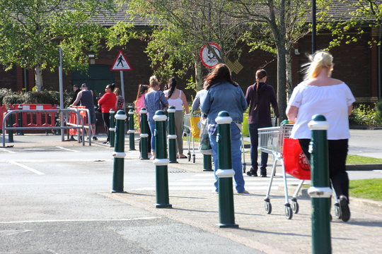 Queuing people with shopping trolleys during Covid Coronavirus pandemic 