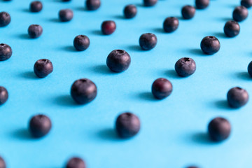 Fresh ripe blueberry berries pattern on a blue background. Shallow depth of field