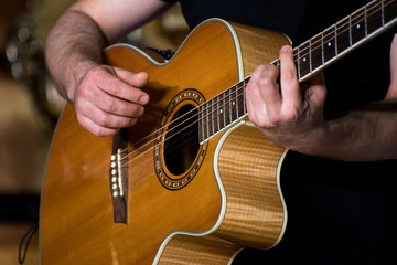 Fototapeta premium Close up of man's hands playing acoustic guitar
