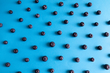 Pattern of natural raw yummy blueberries on a blue background