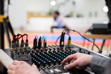 Male sound engineer hands working on sound mixer for recording, broadcasting, music production background