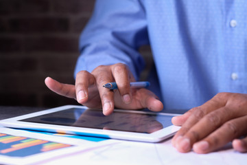 young man working on digital tablet at office desk 