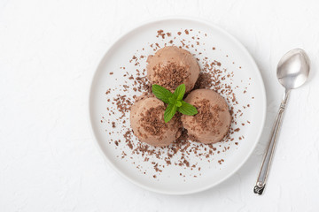 Bowl of chocolate ice cream on white wooden background. From top view