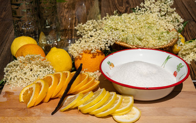 On a cutting board there is a sliced organic lemon and organic orange and a vanilla pod for the...