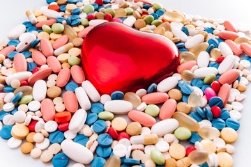 Fototapeta na wymiar Assorted pharmaceutical medicine pills, tablet, and figurine in the shape of a heart.