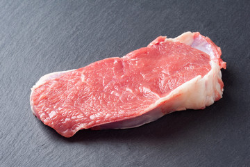 Raw meat. Slice of fresh raw meat on a slate stone. Preparing meat for a barbecue.