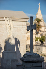 Obraz premium statue of an angel and the cross in a cemetery