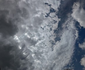 Thunderstorm clouds in the sky. Black-white-gray. A piece of blue sky