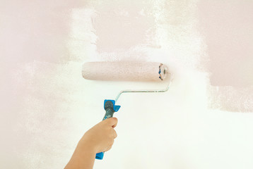 House repair, woman painting wall with pink color