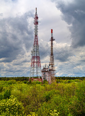 Beautiful landscape with dramatic sky and antenna towers in fresh green forest