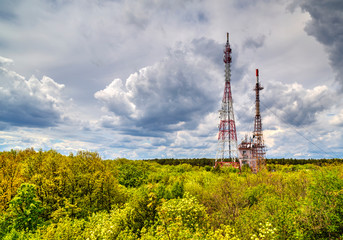 Beautiful landscape with dramatic sky and antenna towers in fresh green forest