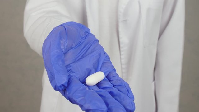 Proctologist with hemorrhoidal suppository, closeup