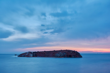 Tanker sunken in a storm near the coast of Odessa, Ukraine. Ship aground near the beach. Landscape at dawn, the blue hour.