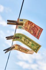 Banknotes hanging on a clothesline, as a symbol of successful investment, concept