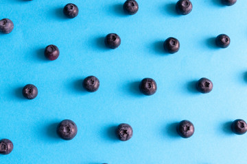 Fresh ripe blueberry berries pattern on a blue background.