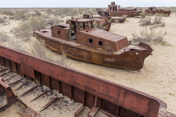 Fototapeta na wymiar Rusty ships at the ship graveyard in former Aral sea port town Moynaq (Mo‘ynoq or Muynak), Uzbekistan