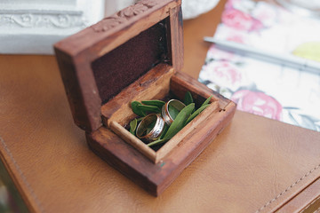 Two gold wedding rings in a beautiful wooden casket with green moss. Wedding accessories. Bride...