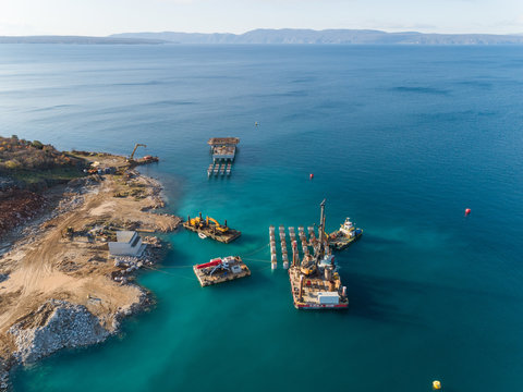 Aerial view of machinery at the construction of future LNG terminal on the shore of the bay in Omisalj, Croatia